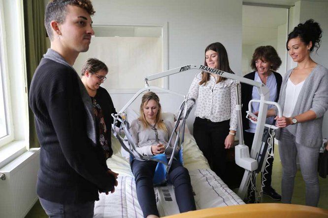 Aide-soignants en formation devant un lit d'hôpital