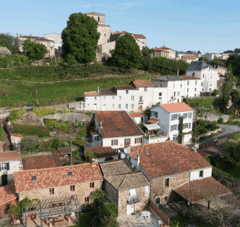 Village avec toits en brique et verdure, colline