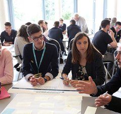 ateliers de petits groupes de 5 à 6 personnes autour de tables dans une salle