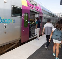 personnes marchant sur un quai et rentrant dans un train Aléop